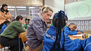 Teacher and child working side by side at elementary school